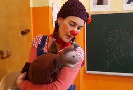 Clownin Pipilotta hält ein Kuscheltier im Arm